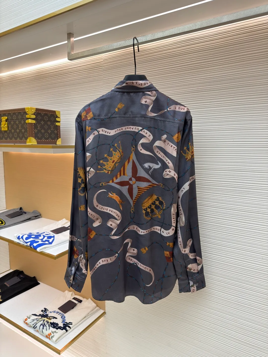LOUIS VUITTON lapel printed mulberry silk shirt ●Original version: Purchased and developed for 17000 ●Item number: 1682218-A85 ●Fabric: worsted mercerized imitation Tencel fabric ●Technology: made by positioning cutting machine ●Color: gray ●Version: fitted version ●Weight: about 190 grams ●Size: S-M-L-XL ●Description: This printed long-sleeved shirt is made of 19mm mulberry silk and cotton blended fabric, which is made through high-density weaving process. The fabric combines the smooth luster of silk with the crisp and breathable characteristics of cotton, and has excellent wrinkle resistance and drape. The body printing adopts digital direct inkjet printing combined with manual overlay screen printing process. First, digital direct inkjet is used to restore the delicate texture and gradient color of the crown, ribbon and other patterns, and then manual overlay screen printing is used to superimpose metallic texture ink to make the three-dimensional relief and glossiness of the pattern more prominent. After high-temperature fixation and water washing tests, the color fastness reaches level 4 or above. The collar of the shirt adopts an inlaid collar design, which is combined with high-temperature pressing and shaping technology to make the collar stiff and not easily deformed; the placket is made of hand-locked hemming technology, and the buttons are made of natural horn buttons, each of which is polished by hand; the side seams are made of French double-needle chain stitching, and the cuffs are designed with adjustable cuffs, showing fine workmanship in every detail. The overall wiring is straight and delicate, the fabric is comfortable and soft, and the color is consistent without color difference. It can be matched with the same style to create a fashionable look and control various occasions. Customized accessories, complete with three standards, same style for men and women!